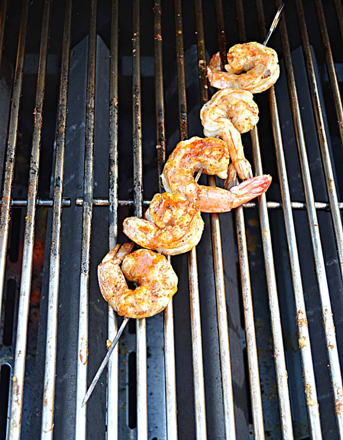 Shrimp on skewers cooking on a grill.