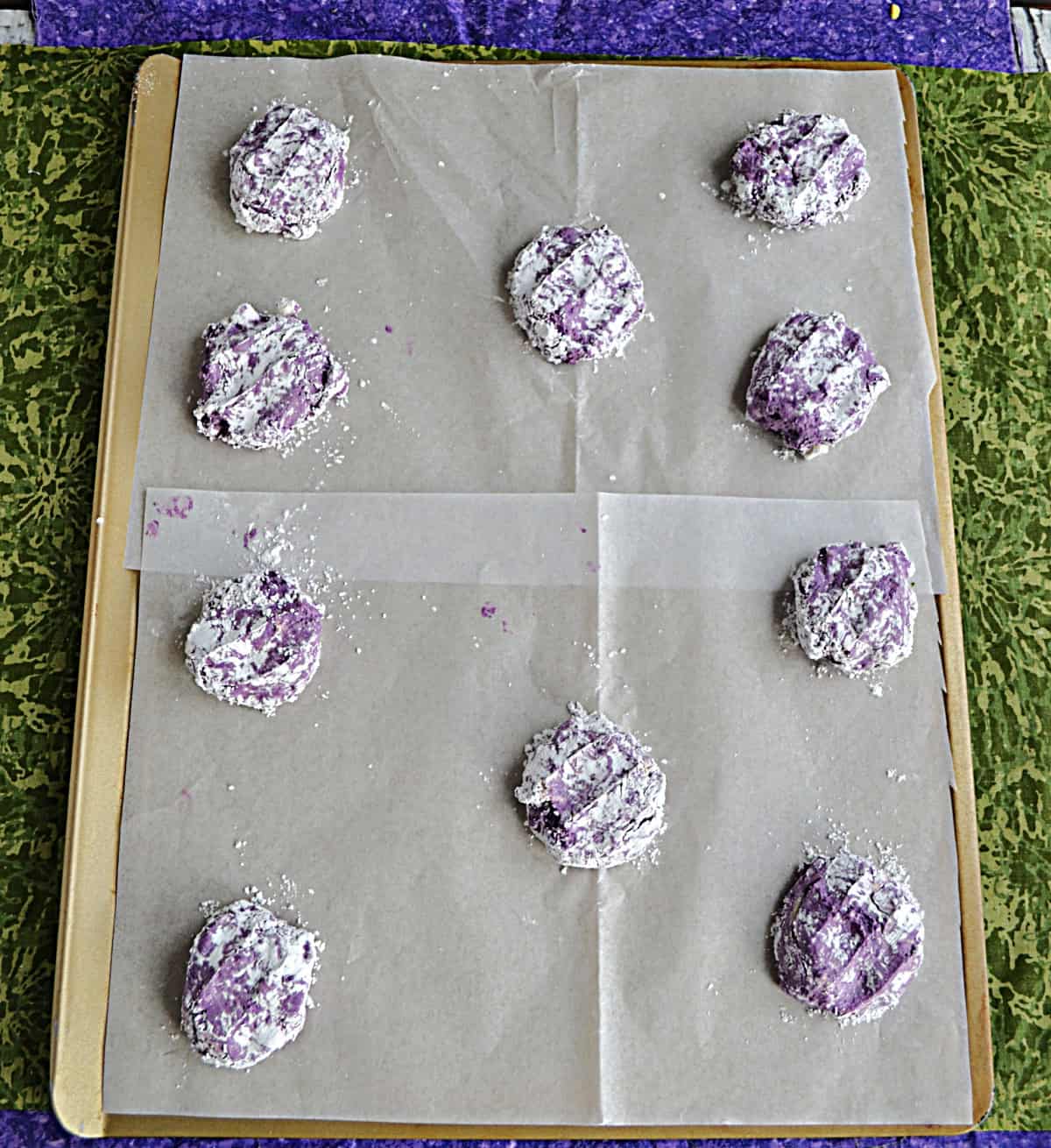 A baking sheet with purple cookie dough balls on it.