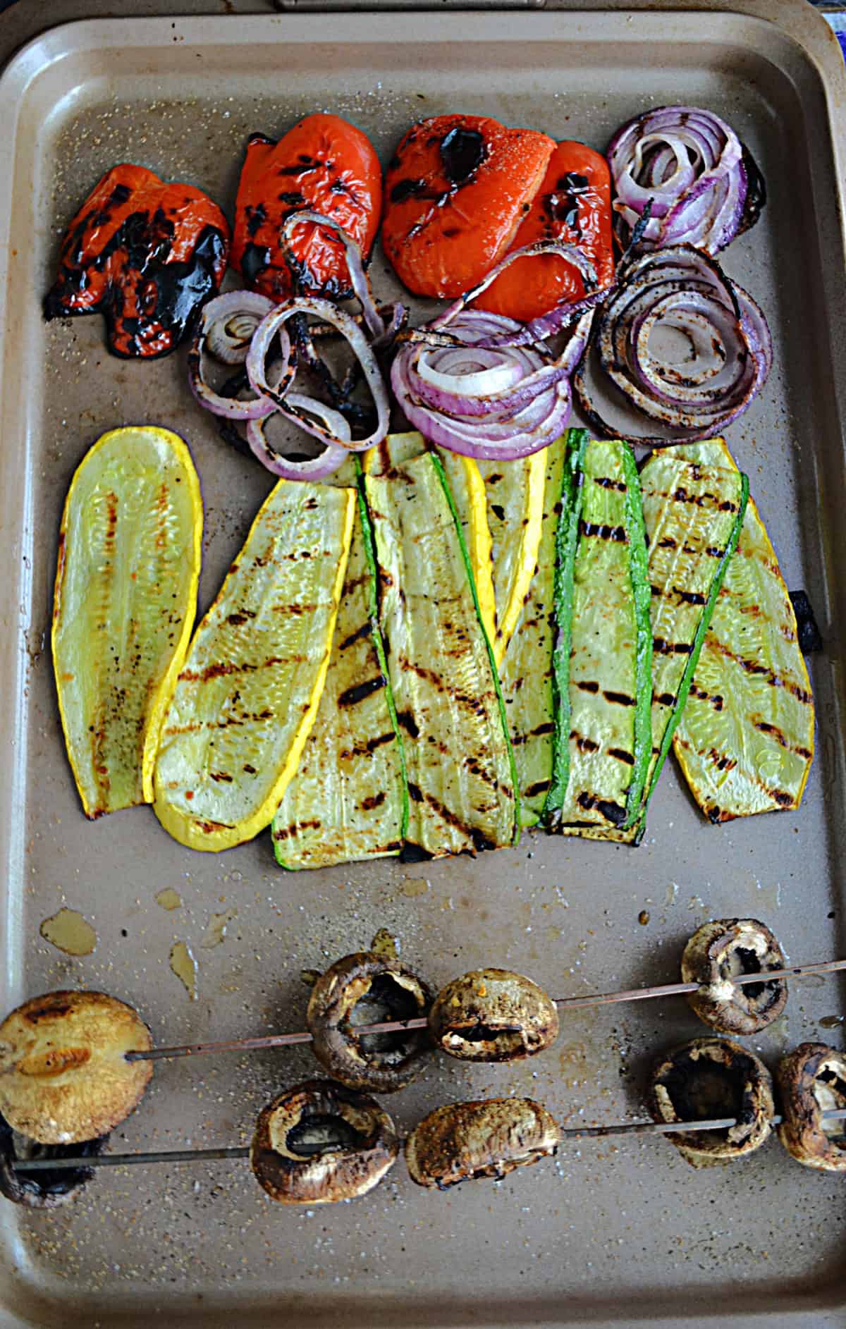 A cutting board with grilled vegetables on it.