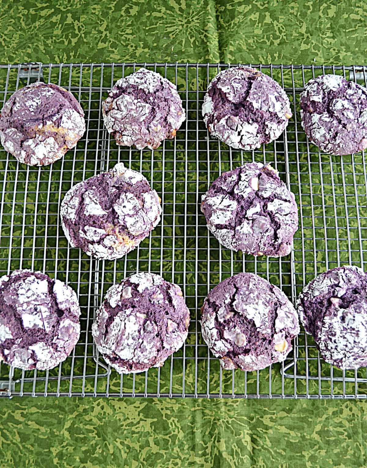 A wire rack with purple cookies on it.
