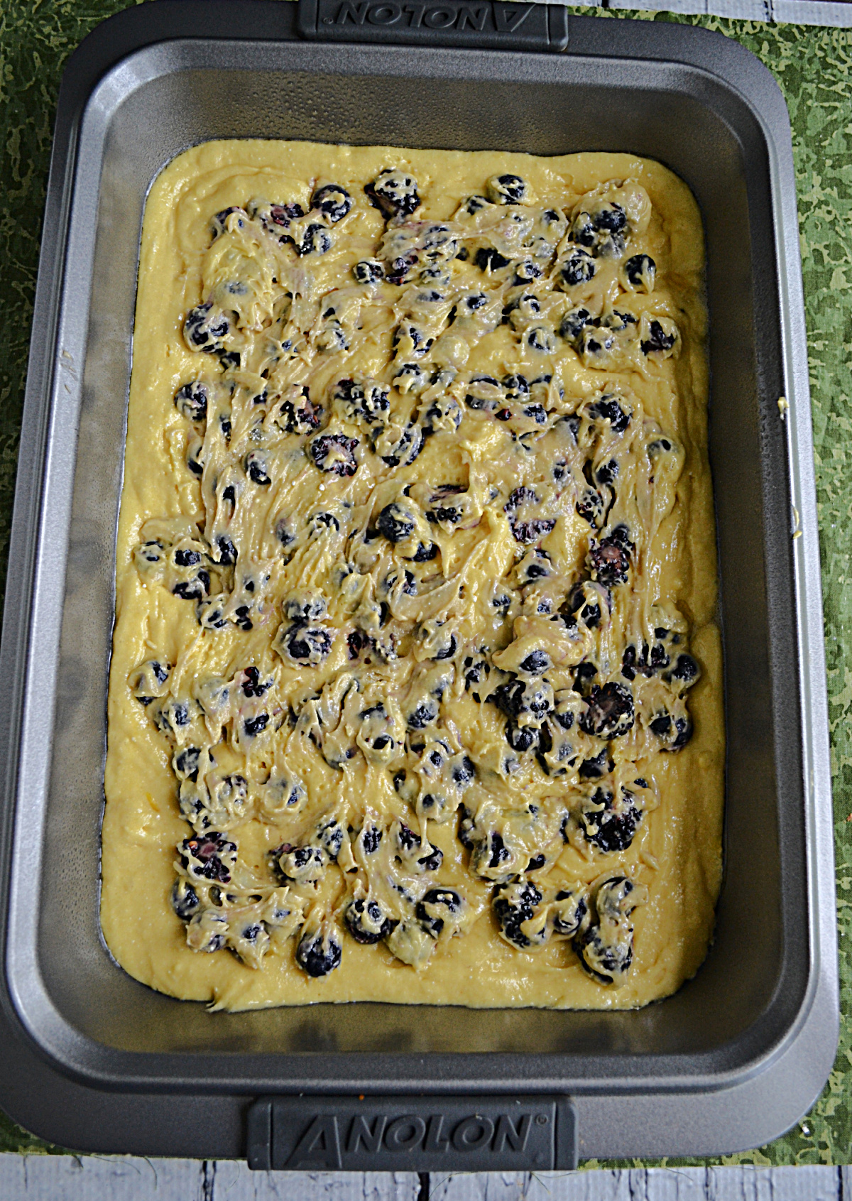 A pan with cake mix and berries in it.
