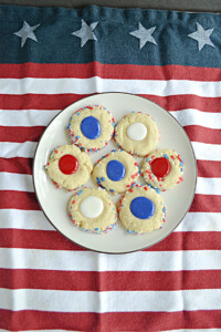 A plate of thumbprint cookies filled with red, white, or blue icing.