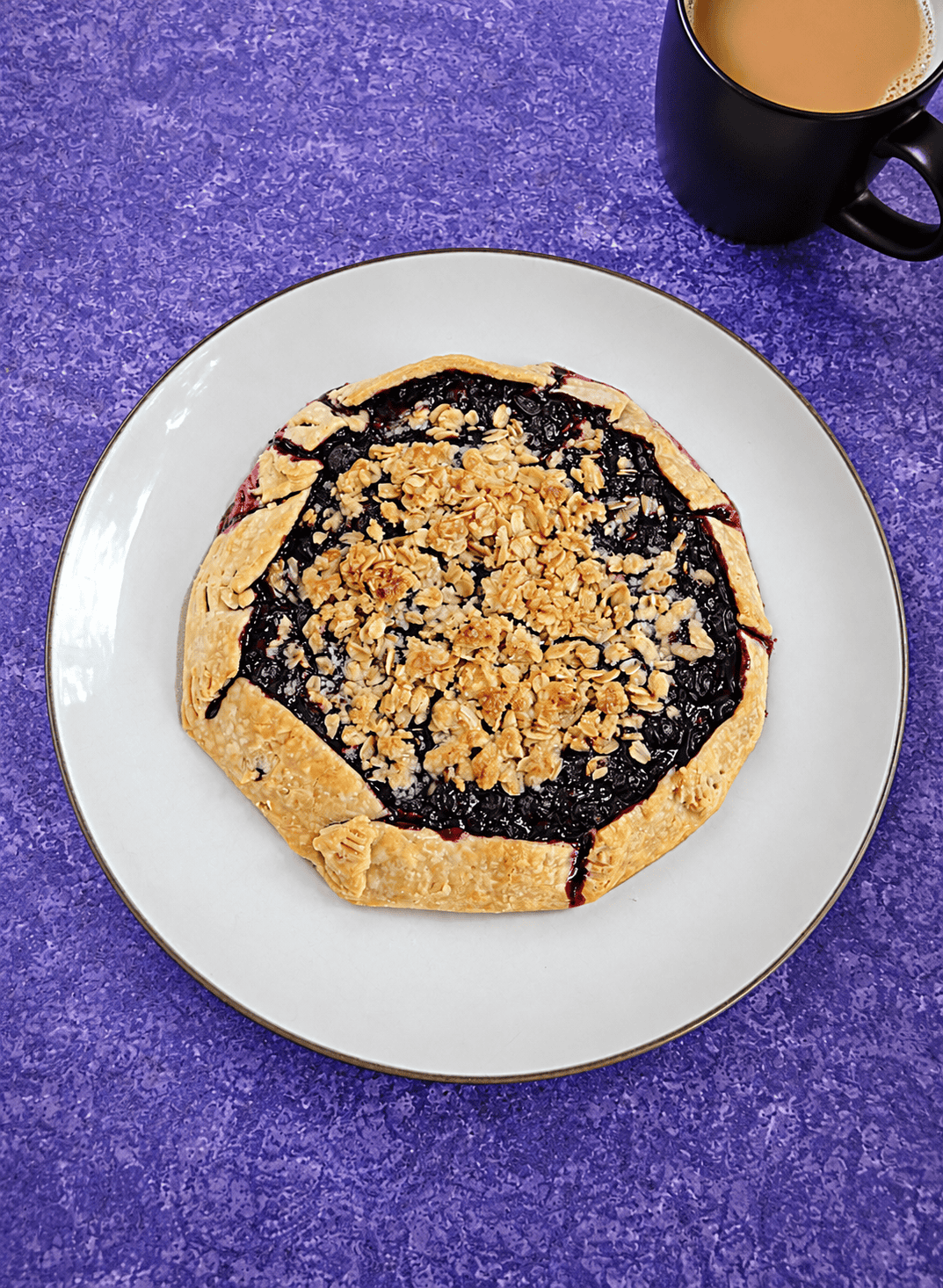 A plate with a golden brown rustin blueberry pie.