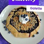 Pin Image: Title, a blueberry galette topped with crumble topping and whipped cream.