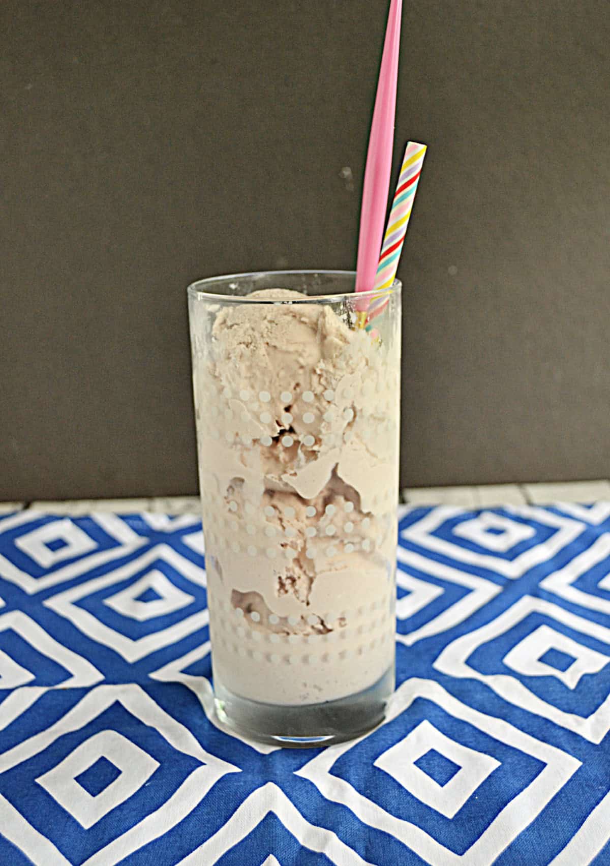 A Frosty in a glass with a spoon and a straw.