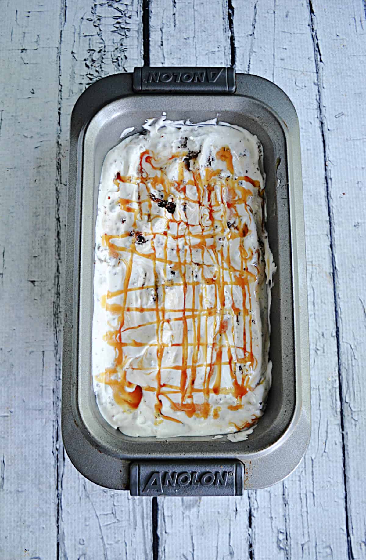 A pan of ice cream with caramel swirls.